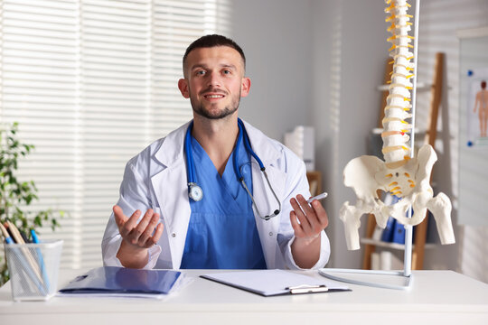 Doctor with human spine model in hospital - Powered by Adobe