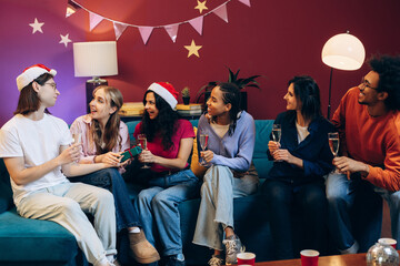 Diverse friends celebrating christmas holiday with gifts and champagne at home