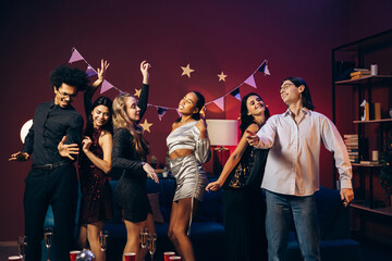 Diverse multinational friends dancing and celebrating at a home party