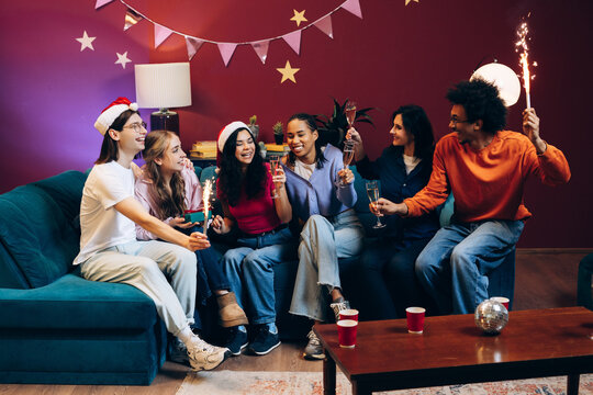 Diverse friends celebrating holidays with sparkling champagne and sparklers