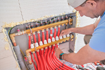 The image showcases a modern plumbing installation featuring red piping, valves, and fittings, illustrating the intricacies of plumbing work and craftsmanship