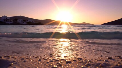 The sun sets over the calm sea, creating a warm glow that reflects on the gentle waves. This beautiful sunset over the sea enhances the serene atmosphere of the peaceful beach.