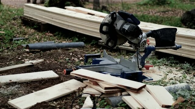 Power saw cutting wood with sawdust flying in a natural outdoor setting
