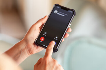 Person using smartphone to decline a call with modern interface and soft background colors