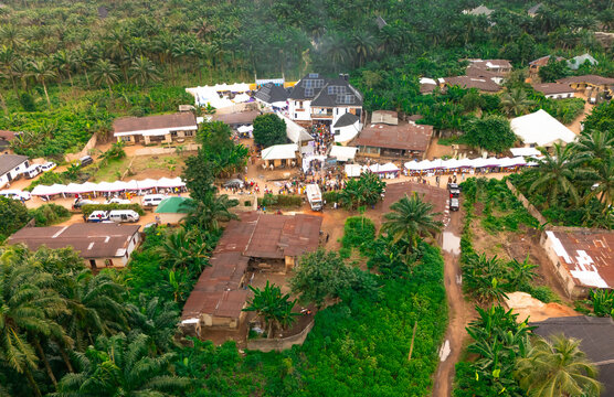 Aerial view of a gathering of people amidst clustered buildings and lush greenery, a scene of vibrant life, Owerri, Imo, Nigeria.