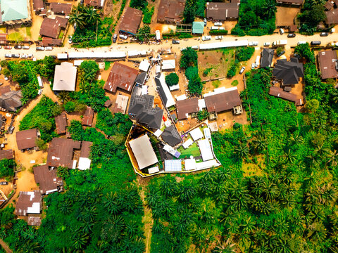 Aerial view of buildings nestled amongst lush greenery and palm trees, a vibrant tapestry of residential architecture, Orlu, Imo State, Nigeria.