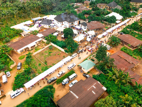 Aerial view of bustling streets lined with cars and vendors amidst the rustic architecture, a vibrant tapestry of life unfolding in this Nigerian town, Owerri, Imo State, Nigeria.