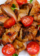 Grilled chicken breast fillet with lattuce salad and cherry tomatoes . Top view on rustic background. High quality photo