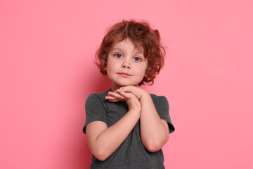 Portrait of cute little boy on pink background
