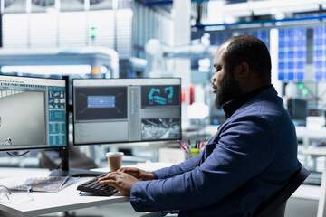 African american industrial employee evaluates solar panel units for defects, ensuring the production process meets quality standards vital to the renewable energy industry success.