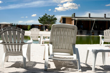 White deck chairs at a recreation center with a freshwater lake