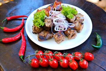Grilled meat platter with ribeye steak, sausages, and tongue in bright natural light, overhead composition. High quality photo