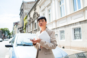 Adult businesswoman looking concerned with smartphone on city street