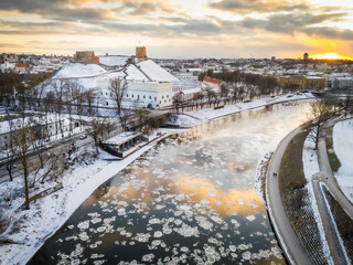 Aerial view of ice floes shimmering on the Neris River beneath the snow-dusted Gediminas' Tower and Upper Castle, Vilnius, Vilnius, Lithuania.