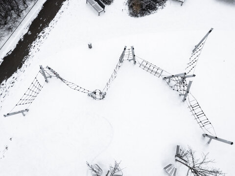 Aerial view of a playground covered in snow, the geometric structure stark against the white canvas, Neris river, Vilnius, Vilnius, Lithuania.