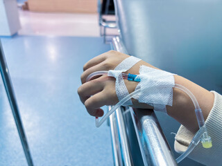 Patient's hand receiving intravenous therapy in hospital, conveying care, recovery and health challenges