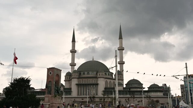 Istanbul, Turkey, August 1, 2025. The New Taksim Mosque in Taksim Square, frontal view on a day with dark skies threatening rain. On the left, the Turkish flag. Travel destinations.