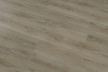 Angled close-up of laminate wood flooring showing natural grain pattern and plank arrangement for construction and design reference.