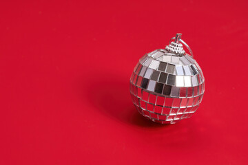 Single Disco Ball. A shiny silver disco ball on a vibrant red background.