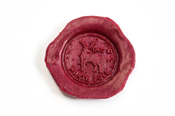 Sealed North Pole Emblem. Red wax seal with a reindeer and North Pole engraving on white background.