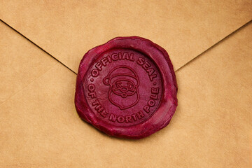Fototapeta premium North Pole Seal. A red wax seal with Santa's face on a brown envelope