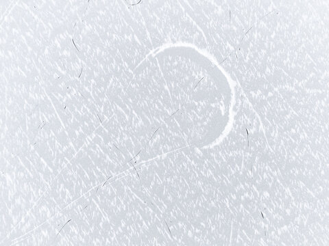 Aerial view of the frozen surface, etched with patterns and a circular mark, reflecting the pale winter light, Trakai, Trakai, Lithuania.