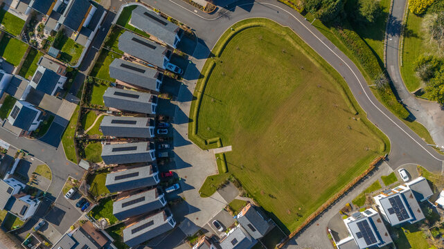 Aerial view of neat rows of houses with dark roofs contrasting with the vibrant green of the central lawn, Exeter, England, United Kingdom.