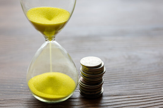 Close-Up of a Yellow Hourglass with Coins