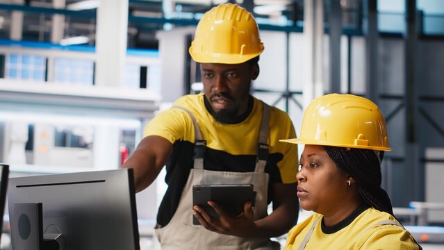 Black employees analyzing production line solar panels in the photovoltaics factory, analyzing data. Manufacturing plant engineers reading documentation files to troubleshoot errors. Camera A.