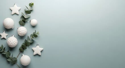 Elegant Christmas ornaments and eucalyptus leaves on a pastel blue background