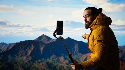 Content creator records a vlog in the mountains sharing his outdoor adventure with his audience....