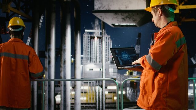 Engineer reviews artificial intelligence systems for offshore oil platform operations, managing fuel extraction through neural networks and deep learning simulation. Fuel production.