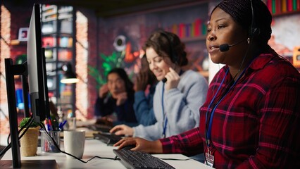 Customer center employee gesturing loud colleague to quiet down during conversation with client. Call center worker upset by noises in office while talking to customers using headphones mic, camera B