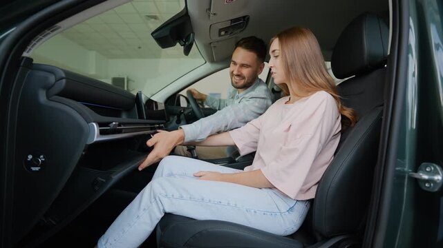 Couple examining the glove compartment in a new right hand drive car