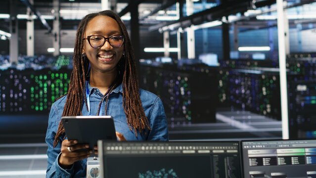 Portrait of upbeat server hub software developer using node tree software to optimize system health. Radiant data center staff member analyzing rigs issues using AI visualization, camera B