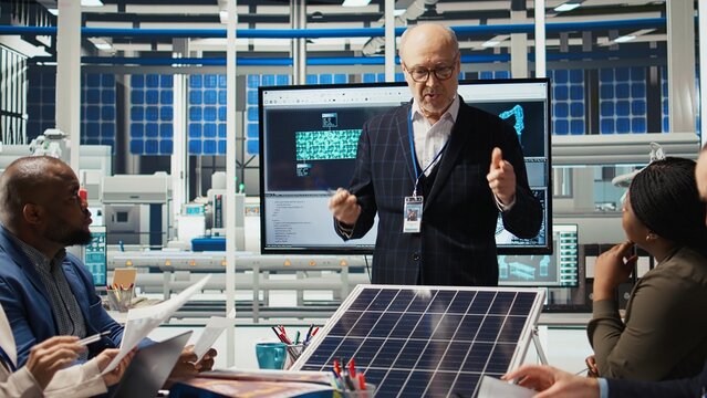 Photovoltaics plant researchers meeting to optimize energy production, analyzing solar cell prototypes. Solar panels plant specialists developing cutting edge manufacturing tech, camera A