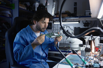 An engineer is meticulously analyzing a circuit board within a controlled laboratory environment