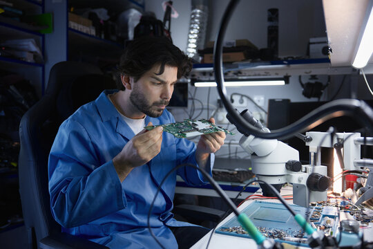 An engineer is meticulously analyzing a circuit board within a controlled laboratory environment