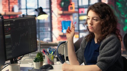 Financial investor works on PC analyzing stock market trends. The digital interface displays price fluctuations, candlestick charts. Liquidity statistics helps strategize future trading decisions