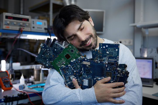 A man holds a large bunch of various electronic components tightly