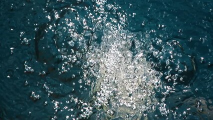Bubbles rise in clear blue water, showcasing dynamic movement and intricate details of the aquatic environment. Concept water, nature, motion, underwater.