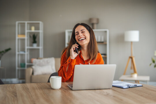Young woman confidently working remotely and talking on phone