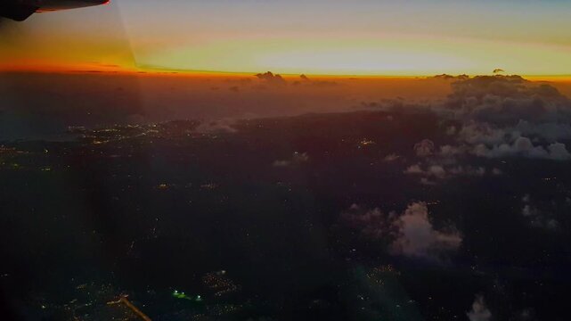 Vue a&eacute;rienne au cr&eacute;puscule. L'horizon embras&eacute; d&eacute;ploie des teintes d'or et de rouge, contrastant avec les nuages sombres d'en bas. Une &eacute;chapp&eacute;e c&eacute;leste, entre ciel et feu.