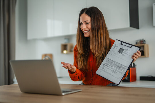Woman presenting financial document during video call from home