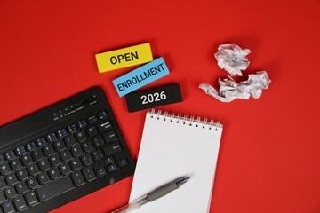 Red background featuring a laptop keyboard, spiral notebook, and pen, with colorful blocks showing Open Enrollment 2026. Great for education, courses, and business enrollment themes.