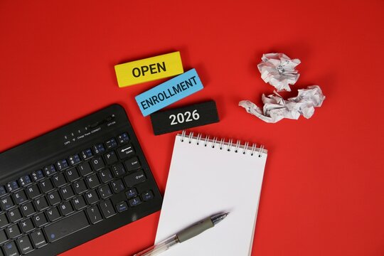 Red background featuring a laptop keyboard, spiral notebook, and pen, with colorful blocks showing Open Enrollment 2026. Great for education, courses, and business enrollment themes.