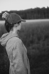 Direction and Goal: A black and white shot of a woman in a sports sweatshirt and cap, looking into the horizon, symbolizing motivation, purpose and contact with the fresh air.