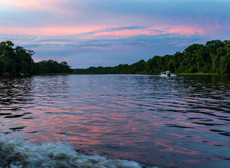 Sunset with a tour boat sailing along the canals in the Tortuguero National Park of Costa Rica