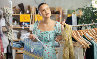 Asian woman view assortment in clothing department, buying summer clothes. 