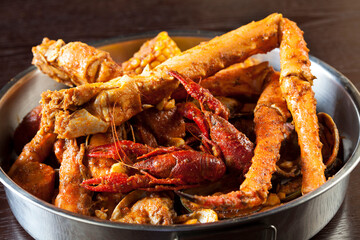 Alaskan crab legs, crawfish, and lobster in a large metal bowl. 